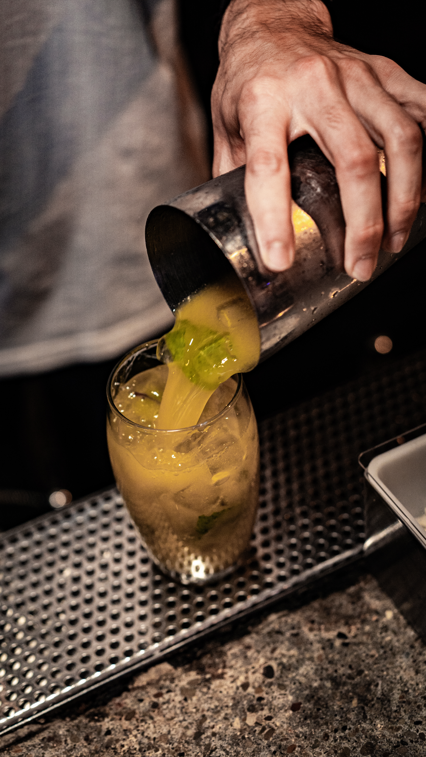 A finished margarita on El Camión Cantina's branded bar mat, glowing against the backbar.